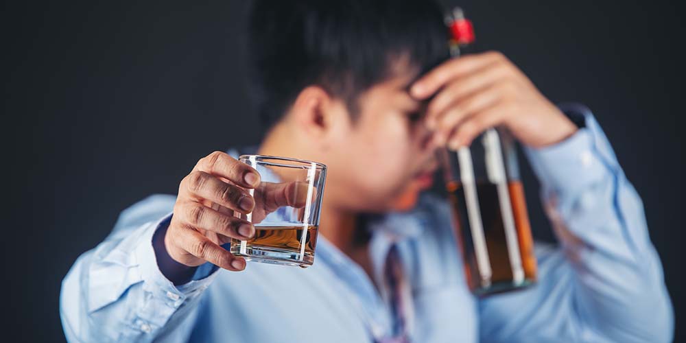 Handsome handsome man drinking whisky at home