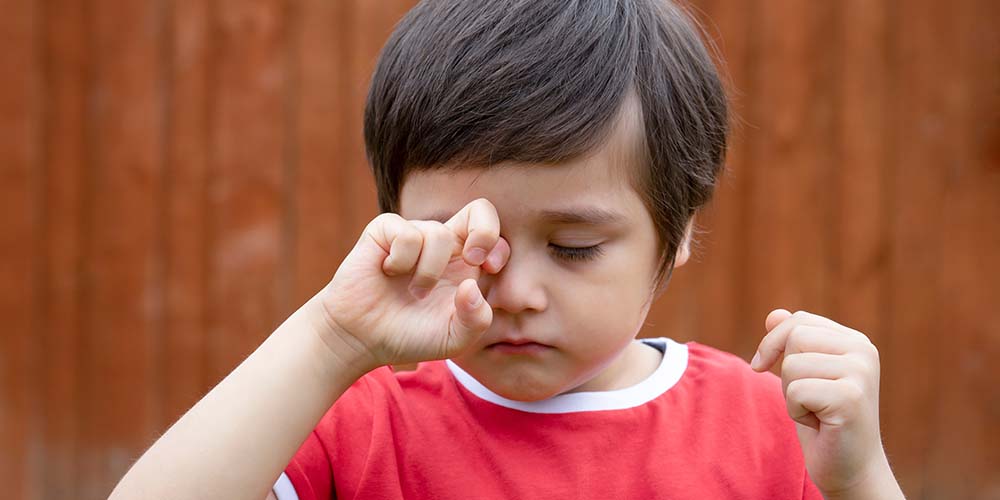 Little boy is having allergy rubbing his eye, Kid scratching his
